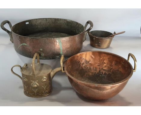 A large 19th century copper double handle preserving bowl, a copper dough kneading bowl, a brass watering can, copper ladle a