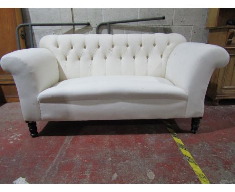 A late Victorian button back sofa with scrolled arms on turned supports, freshly upholstered in calico, 170cm wide (single dr