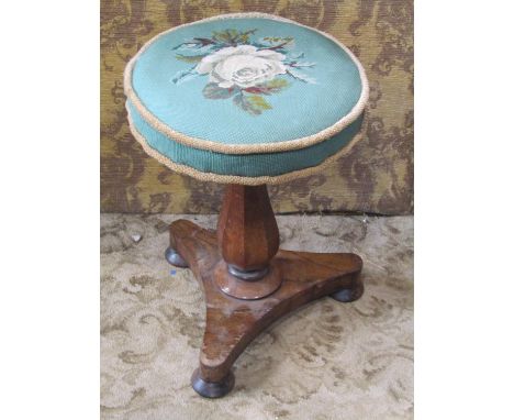 A 19th century rosewood veneered piano stool with adjustable circular revolving floral tapestry upholstered seat raised on a 