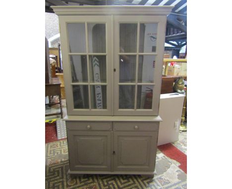 A Georgian style cabinet the lower section enclosed by two panelled doors and two frieze drawers, the upper section with astr