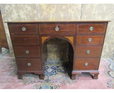 An Edwardian inlaid mahogany kneehole writing desk of nine drawers, the central arch with further inlaid detail, raised on br