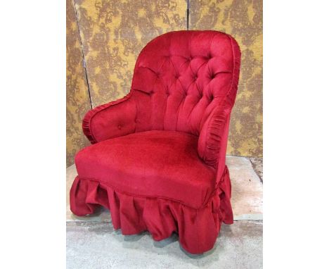 A Victorian button back drawing room chair upholstered in red velvet and raised on turned supports 