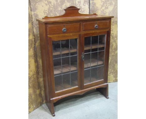 An Edwardian mahogany side cupboard with leaded light doors and two frieze drawers 