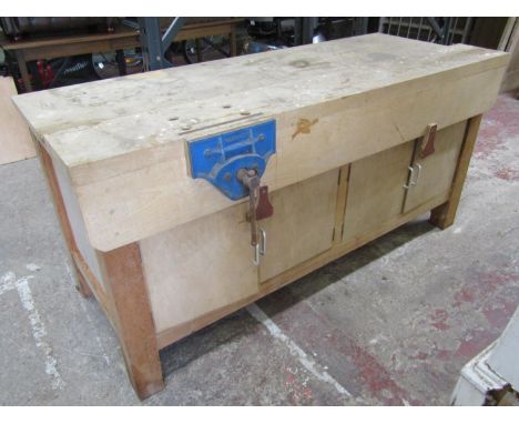 A good workshop bench in mixed timbers with integral vice and enclosed base, 186 cm in length 