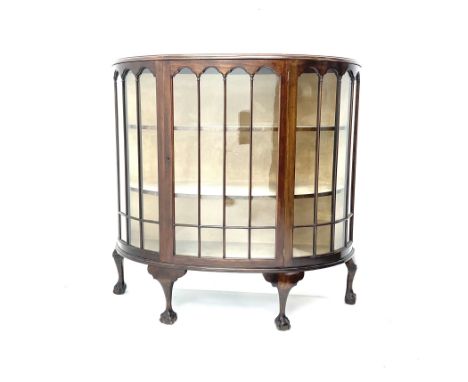 Early 20th century mahogany demi-lune display cabinet, single glazed door enclosing two lined shelves, ball and claw feetDime