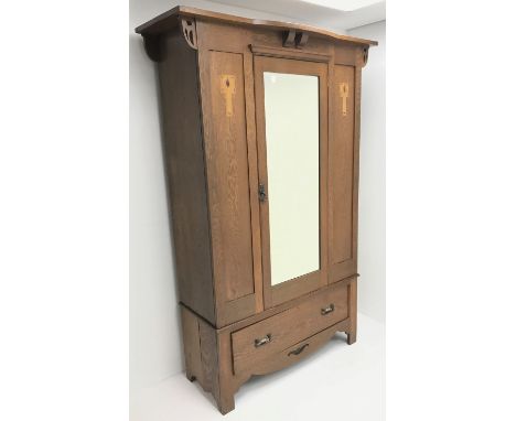 Arts and Crafts period oak wardrobe, projecting shaped cornice, single bevel edged mirrored door above drawerDimensions: Heig