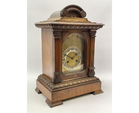 Late 19th/early 20th century walnut bracket clock, the architectural case with arched pediment over projecting egg and dart c