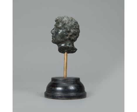 Male Head, in ancient manner, looking to the side, with curled hair, serpentine stone, hand sculpted, on later ebonized woode