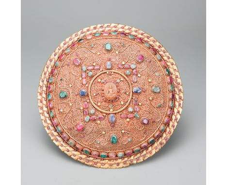 Tibetan Breast Shield, of a Lama priest, round arched shape, copper filigree work, partly gilded, with rich precious stones (