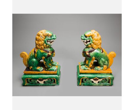 Pair of Chinese Lions, ceramic sculpted, green, yellow and brown coloured and glazed, base with open work, on the underside p