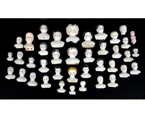 Collection of thirty-nine 19th century and later bisque porcelain dolls heads varying in size, largest 5.5cm high, smallest 2