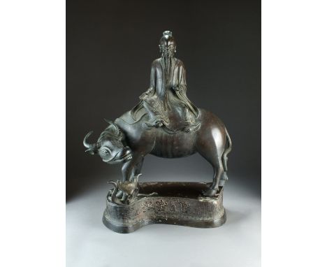 A large Chinese bronze figure of Laozi on a buffalo, Qing Dynasty, the philosopher seated and holding a scroll in his right h