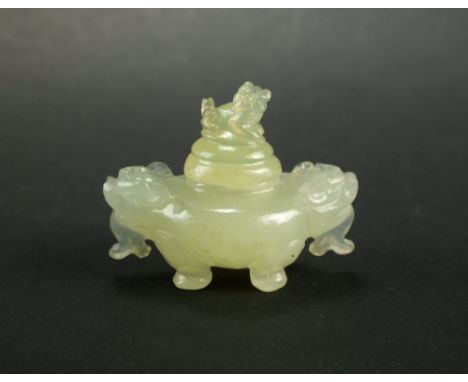 A Chinese celadon jade miniature tripod censer and cover, with foo dog finial and zoomorphic handles, 3cm high.