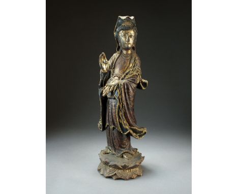 A Chinese carved, painted and parcel gilt wood figure of Guanyin, late Qing Dynasty, the goddess modelled standing with right