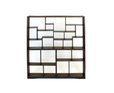 A Chinese hardwood scholar's open shelf, of rectangular outline with moulded top and sides framing multiple recesses varying 