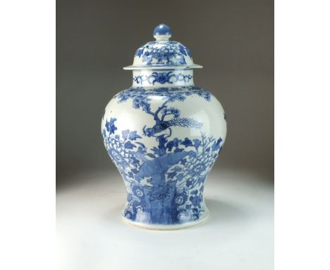 A Chinese blue and white vase and cover, 19th century, of baluster form, the domed cover with cone finial, painted with a bir