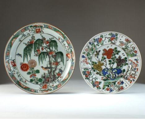 A Chinese famille verte dish, Kangxi, of plain circular form and decorated with flowering plants and rocks within a panel bor