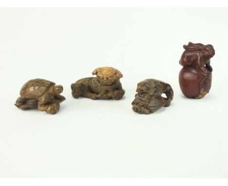 Four Japanese carved wood netsuke, 19th/early 20th Century, the first a reclining shishi, 5cm long, the second a lion on a tu