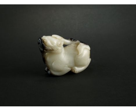 A grey and black nephrite jade figure of a qilin, modelled seated, 4.5cm high.