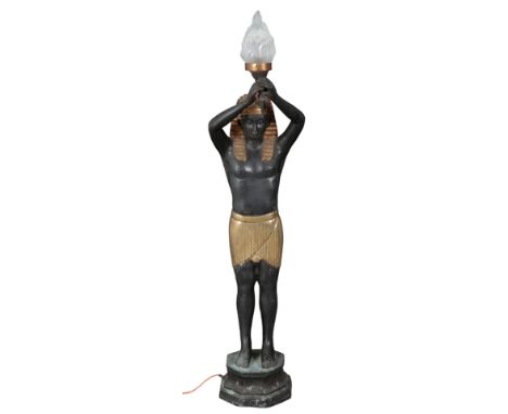 A CAST METAL FIGURAL STANDARD LAMP in the form of a pharaoh holding a flame aloft, on a pedestal base, 140cm high