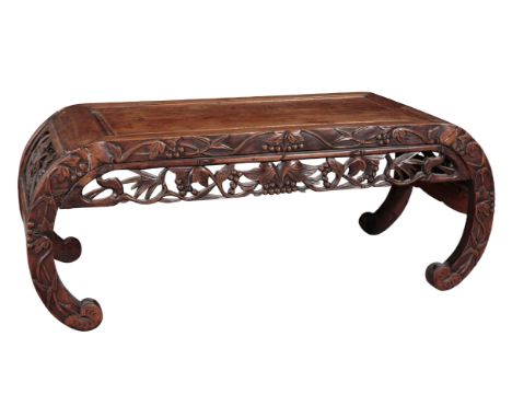 A CHINESE HARDWOOD LOW TABLE 20th century, the frieze decorated with carved and pierced foliage, on scroll legs, 35cm high x 