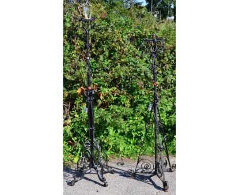 Two black wrought iron standard lamp stands with scrollwork decoration 