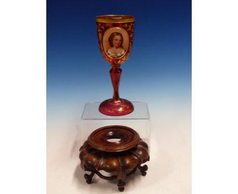 A BOHEMIAN GILT RUBY GLASS GOBLET ON A CHINESE WOOD STAND.