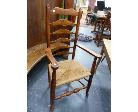 A COUNTRY ELM AND ASH LADDER BACK ARMCHAIR WITH ROUNDED FINIALS.