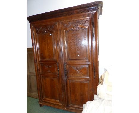 A FRENCH PROVINCIAL CARVED OAK ARMOIRE WITH TWO FULL HEIGHT PANEL DOORS ENCLOSING HANGING AND SHELF SPACE.   160 x 65 x H.222