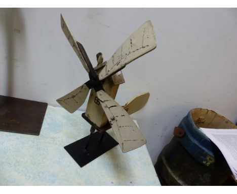 A PAINTED WOOD WEATHER VANE IN THE FORM OF A WINDMILL THE SAILS MOVING A SEGMENTAL FIGURE OF A MAN BEHIND AS HE STANDS BEFORE