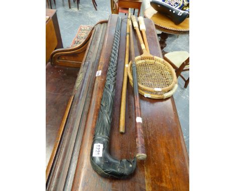 AN AFRICAN EBONY WALKING STICK WITH ELEPHANT HANDLE, TWO SQUASH RACKETS,A GOLF STICK GAFF AND ANOTHER CANE