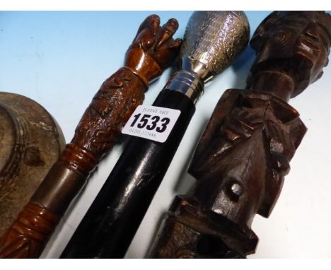 AN INDIAN WHITE METALLED TOPPED EBONISED WALKING CANE, A FRUITWOOD CANE WITH BALL AND CLAW CARVED HANDLE, A TRIBAL CANE TOP C