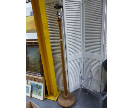 AN OAK HEALS STANDARD LAMP, THE TULIP SHAPED TOP ON A HEXAGONAL COLUMN FLARING TO A CIRCULAR FOOT, THE WOODWORK.   H 157cms.
