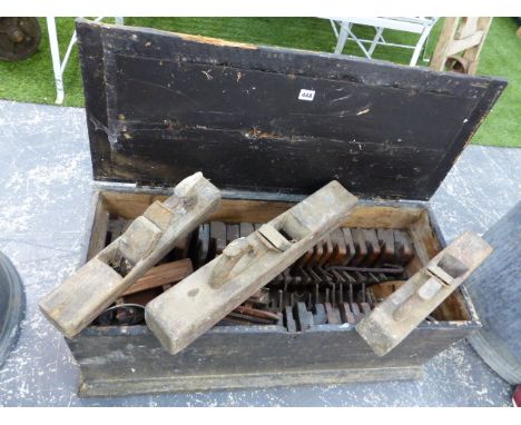 AN ANTIQUE PINE TOOL CHEST CONTAINING A GOOD SELECTION OF WOODEN MOULDING PLANES AND OTHER TOOLS.  (QTY)