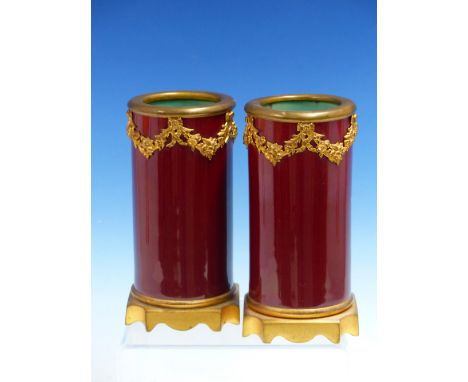 A PARIS PORCELAIN JUG GILT WITH GERMAN INSCRIPTION DATED 1833.   H 22cms. A PAIR OF ORMOLU MOUNTED RUBY GLAZED CYLINDRICAL VA