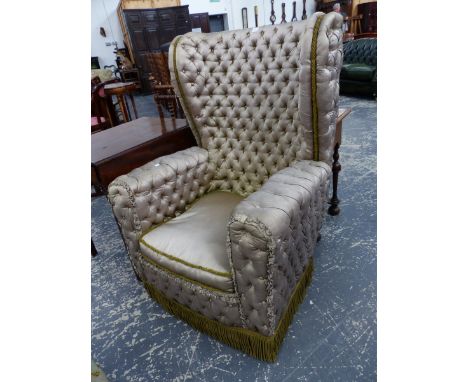 AN UNUSUAL ANTIQUE WING BACK ARMCHAIR WITH SILK CLOSE BUTTON UPHOLSTERY.