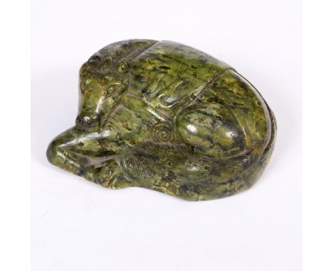A CHINESE DARK GREEN AND BLACK STRIATED JADE PEBBLE 17th century, carved as a recumbent horse with its head resting upon its 