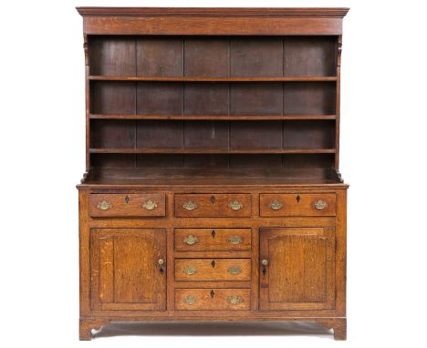 A GEORGE III OAK DRESSER with three shelf plate rack above, the base with six drawers and two panel cupboard doors, all stand