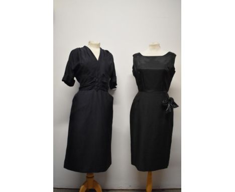 A 1950s navy blue dress, having pleats to central bodice with faux button decoration to centre, two pockets and turned up cuf