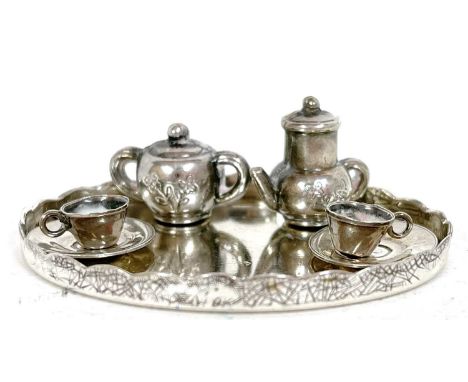 A miniature white metal tea set comprising an oval tray, teapot, sucrier, two cups and two saucers, marked 925