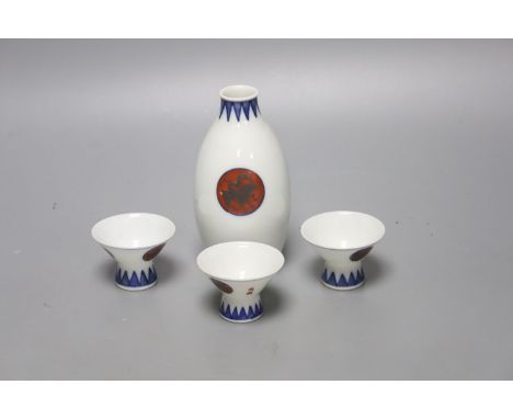   A Japanese blue and white porcelain sake flask, with associated cups, height 12cm