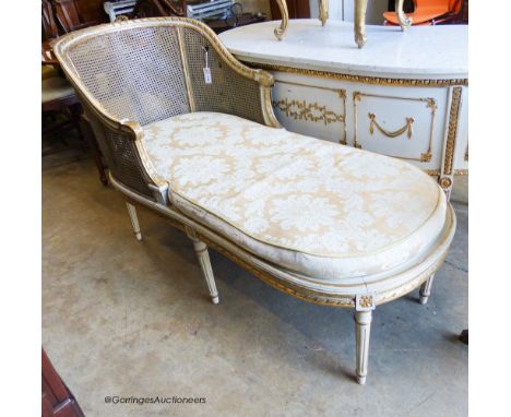   A Louis XVI style painted, giltwood and caned daybed (faults), length 152cm, width 66cm, height 93cm