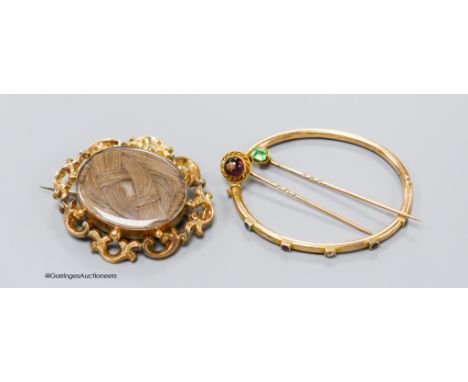   A Victorian yellow metal oval mourning brooch, with glazed panel above plaited hair, 57mm, gross 20.9 grams, a 9ct, ruby, s