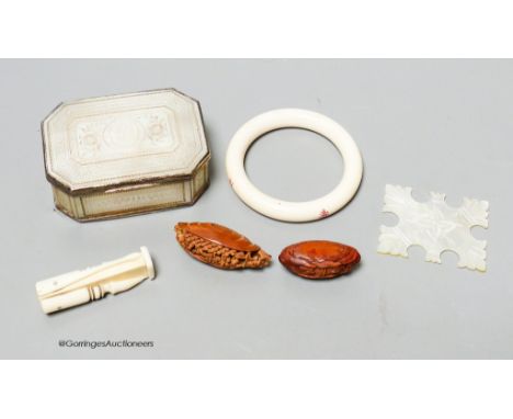   A 19th century panelled mother of pearl box together with a Chinese carved peach stone, a Chinese ivory bangle and a small 