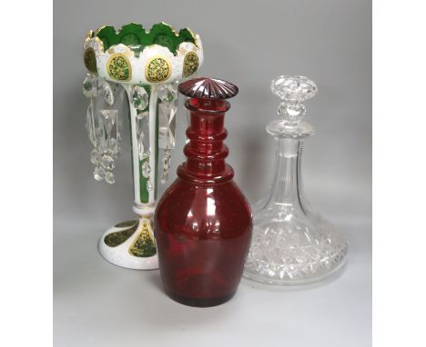   A rare ruby glass decanter circa 1830, a Bohemian overlaid glass table lustre and a cut clear glass ship's decanter, talles