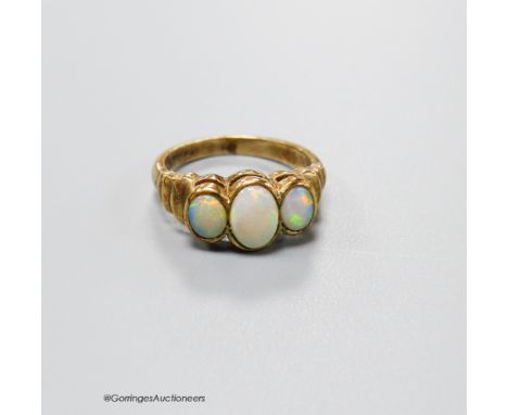   A 9ct gold and three stone white opal set half hoop ring, with ribbed shoulders, size K, gross 3.5 grams.