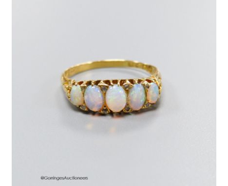   An Edwardian 18ct gold and graduated white opal set half hoop ring, with diamond chip spacers, size Q, gross 3.5 grams,one 