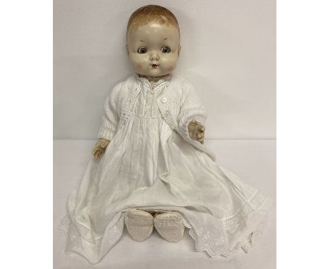 A vintage plastic baby doll with rosebud mouth, moving eyes and cryer.  Dressed in an Edwardian babies nightgown with embroid