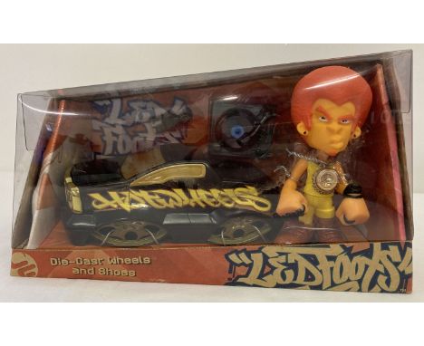 A boxed Hot Wheels Led Foots vehicle and character set from Mattel, 2004.  With diecast wheels and shoes. 