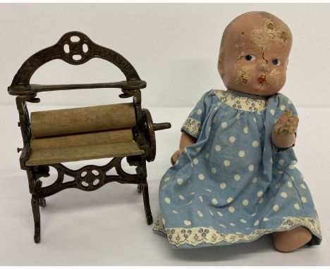 An antique cast metal and wooden toy mangle. Registered mark for 1914, approx. 16cm tall.  Together with a vintage composite 